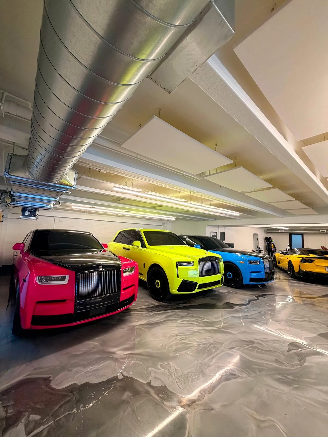 Three wrapped Rolls-Royce Cullinans and a supercar inside a private garage